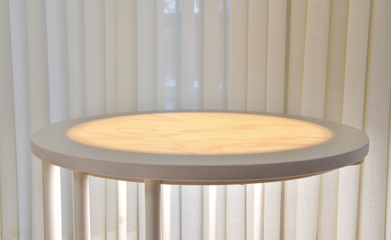 AICCI round wooden bedside table with a LuminousWood tabletop that illuminates.